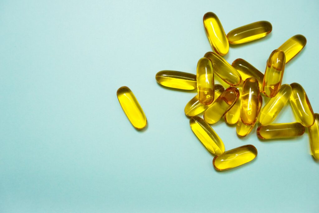 Comprimidos e cápsulas de suplemento em tons de marrom e amarelo sobre uma superfície