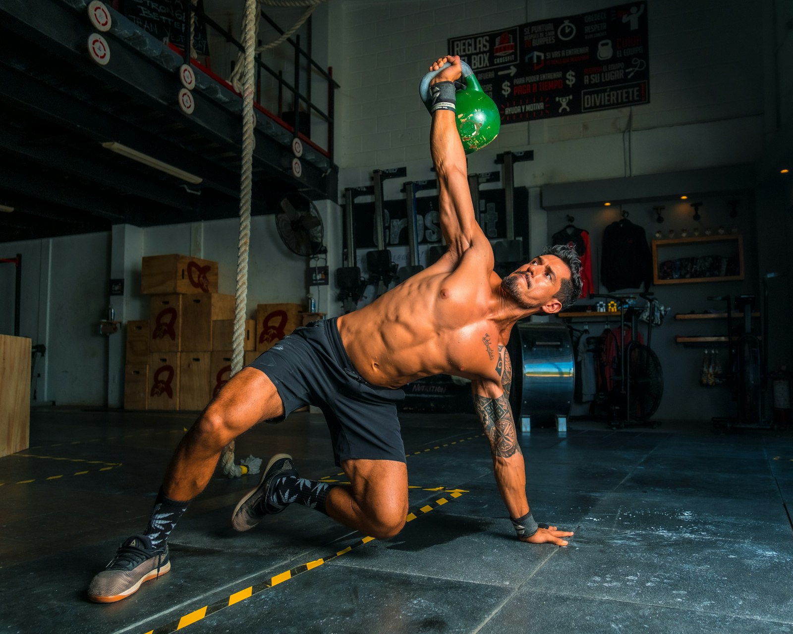 Homem realizando exercício com kettlebell em academia, ilustrando treino de força