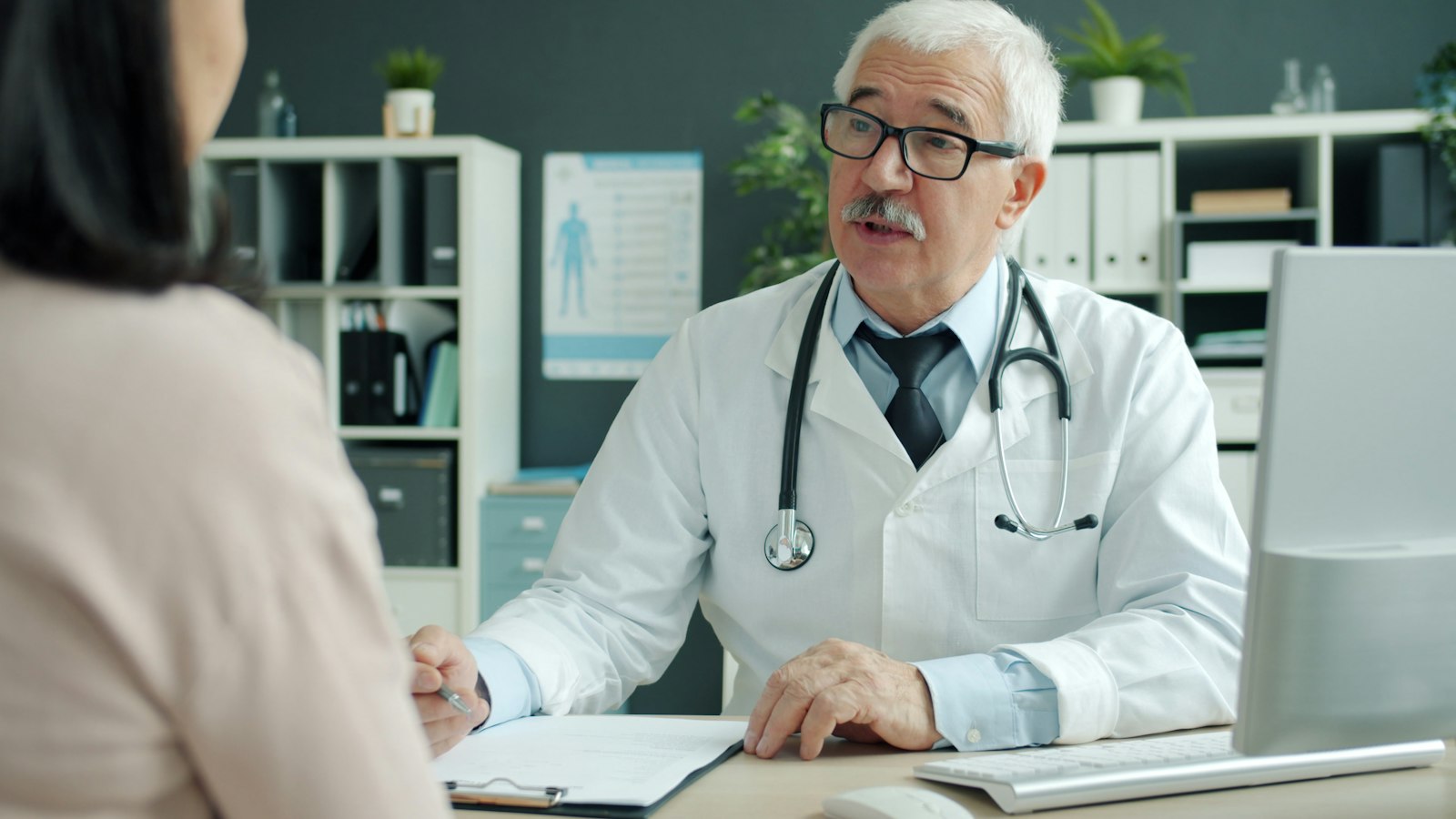 Médica conversando com paciente durante consulta em clínica, ilustrando a importância de buscar orientação profissional antes de suplementar