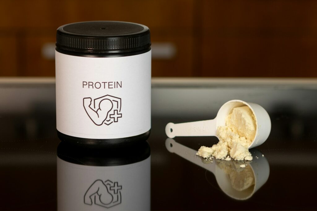 Pote e dosador de suplemento proteico, remetendo a suplementação para recuperação muscular