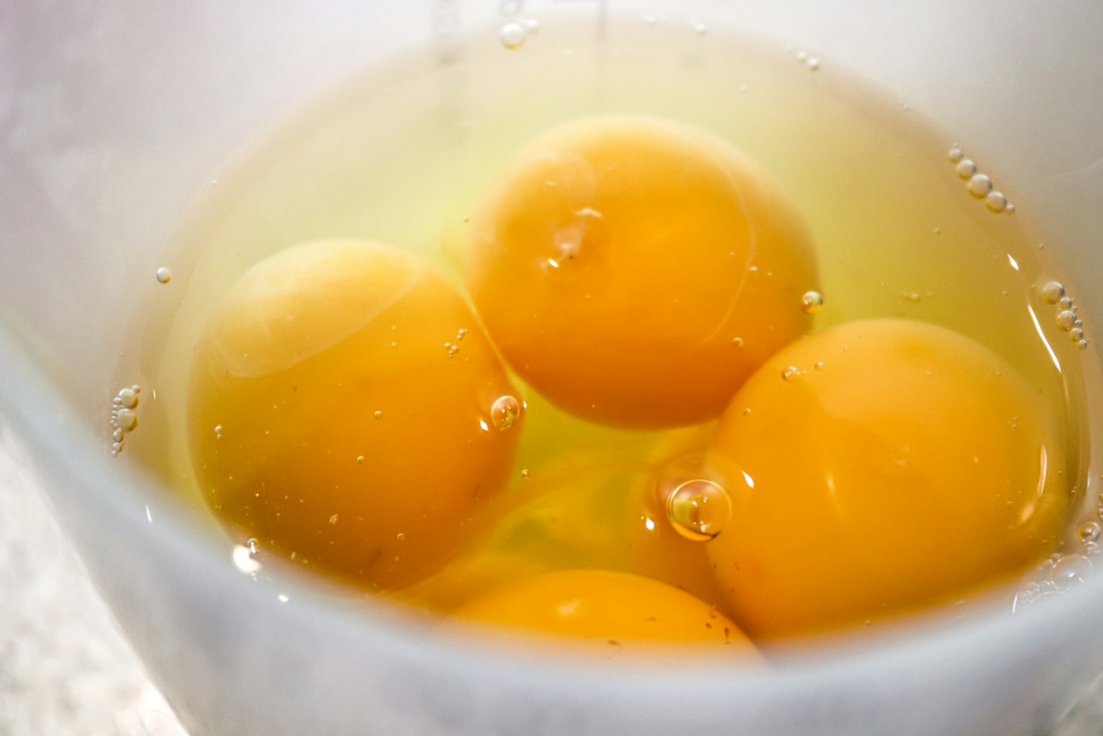 Gemas de ovo cru em tigela, fonte alimentar de vitamina K2