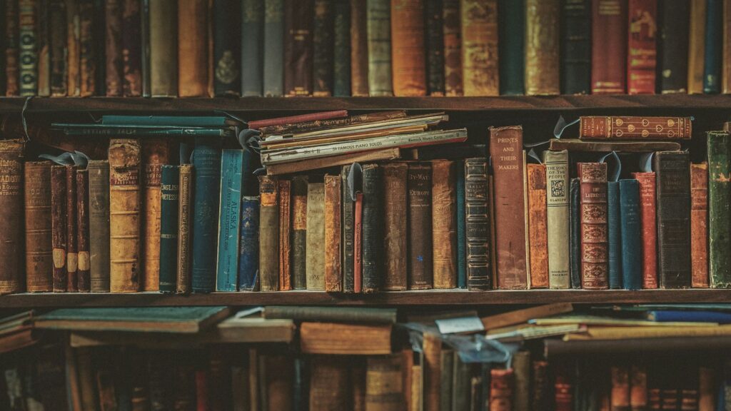 Pilha de livros organizados em estante de madeira, representando a literatura científica publicada